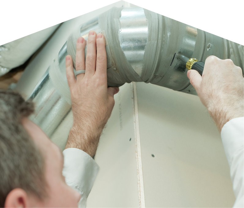 Mersey HVAC technician inspecting and tightening a joint on a sealed metal air duct, performing maintenance work during an air duct cleaning task. Mersey HVAC technician inspecting and tightening a joint on a sealed metal air duct, performing maintenance work during an air duct cleaning task.