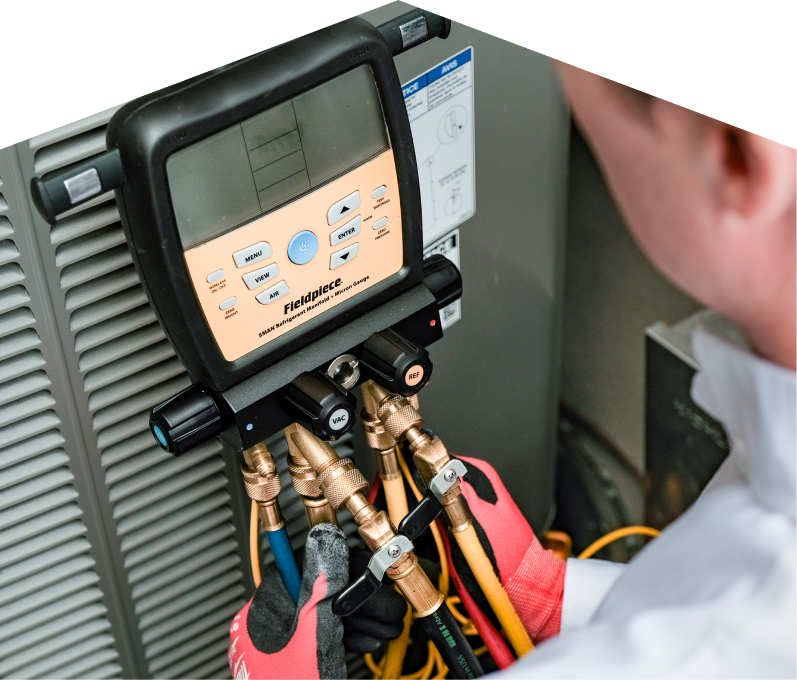 A Mersey home service crew member uses a digital manifold gauge to check refrigerant levels on an HVAC unit for service. A Mersey home service crew member uses a digital manifold gauge to check refrigerant levels on an HVAC unit for service.
