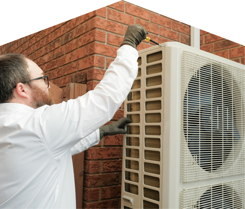 Mersey HVAC specialist using a screwdriver to complete a heat pump installation beside a brick wall. Mersey HVAC specialist using a screwdriver to complete a heat pump installation beside a brick wall.