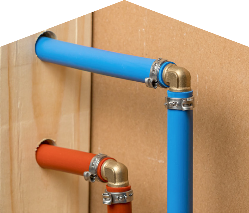 Mersey kitec plumbing system with blue and orange plastic pipes connected by brass fittings and metal clamps, mounted on a wooden panel. Mersey kitec plumbing system with blue and orange plastic pipes connected by brass fittings and metal clamps, mounted on a wooden panel.