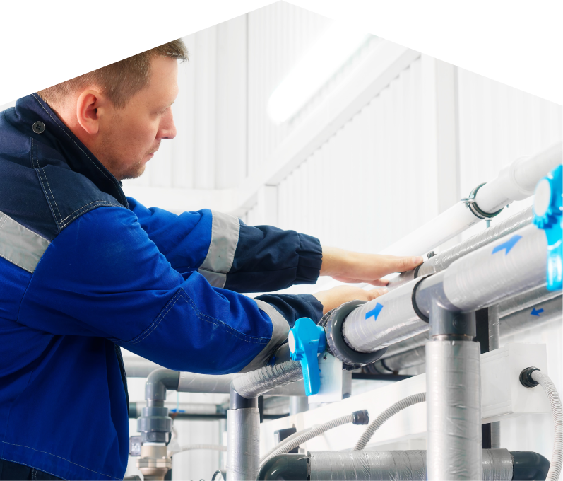 Mersey water damage and restoration specialist in a blue uniform adjusts insulated piping on a water system inside a bright utility room. Mersey water damage and restoration specialist in a blue uniform adjusts insulated piping on a water system inside a bright utility room.