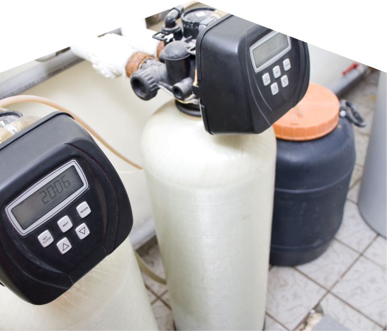 Mersey water softener installation showing dual resin tanks with digital control heads and a brine tank in a tiled utility area. Mersey water softener installation showing dual resin tanks with digital control heads and a brine tank in a tiled utility area.