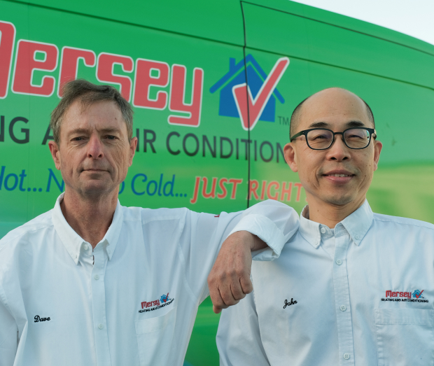 Smiling Mersey technician standing confidently in front of their green service van, wearing their white issued uniform. Smiling Mersey technician standing confidently in front of their green service van, wearing their white issued uniform.