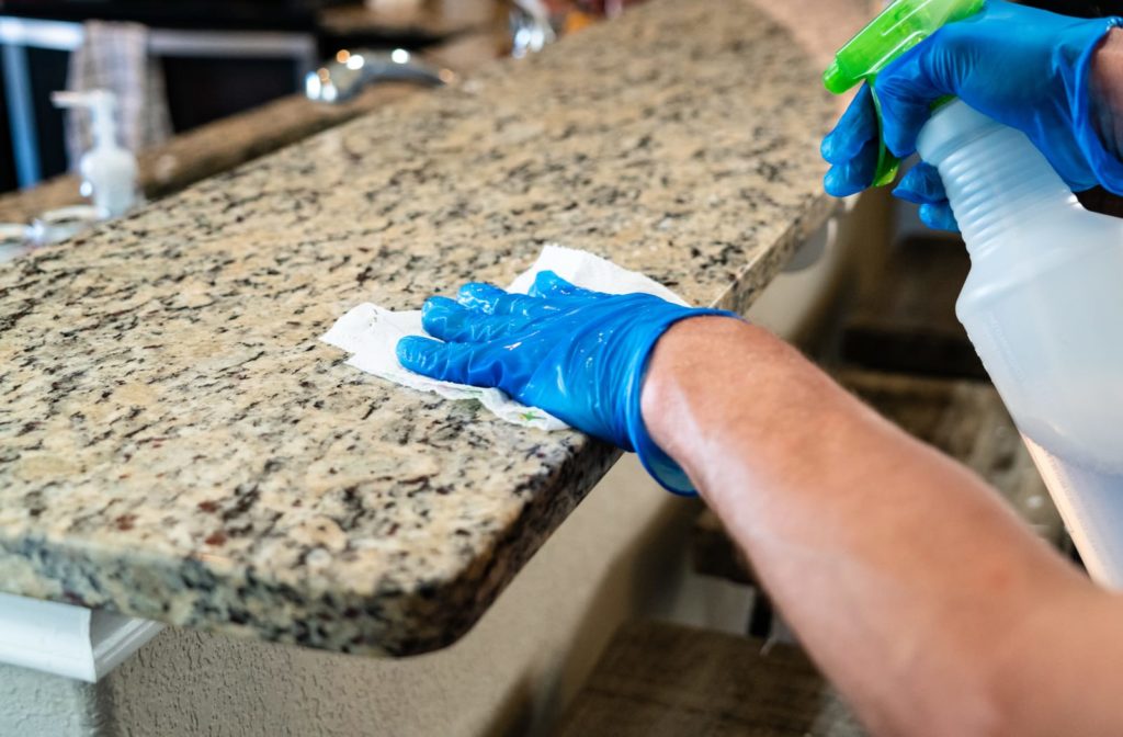 Person cleaning the counter in their home to protect from COVID-19.